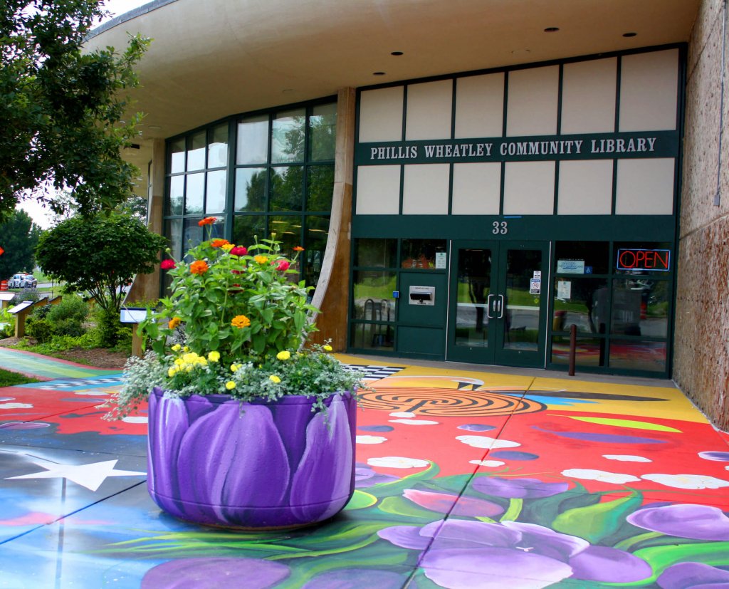 Exterior of Phillis Wheatley Community Library with a vibrantly painted sidewalk mural. 