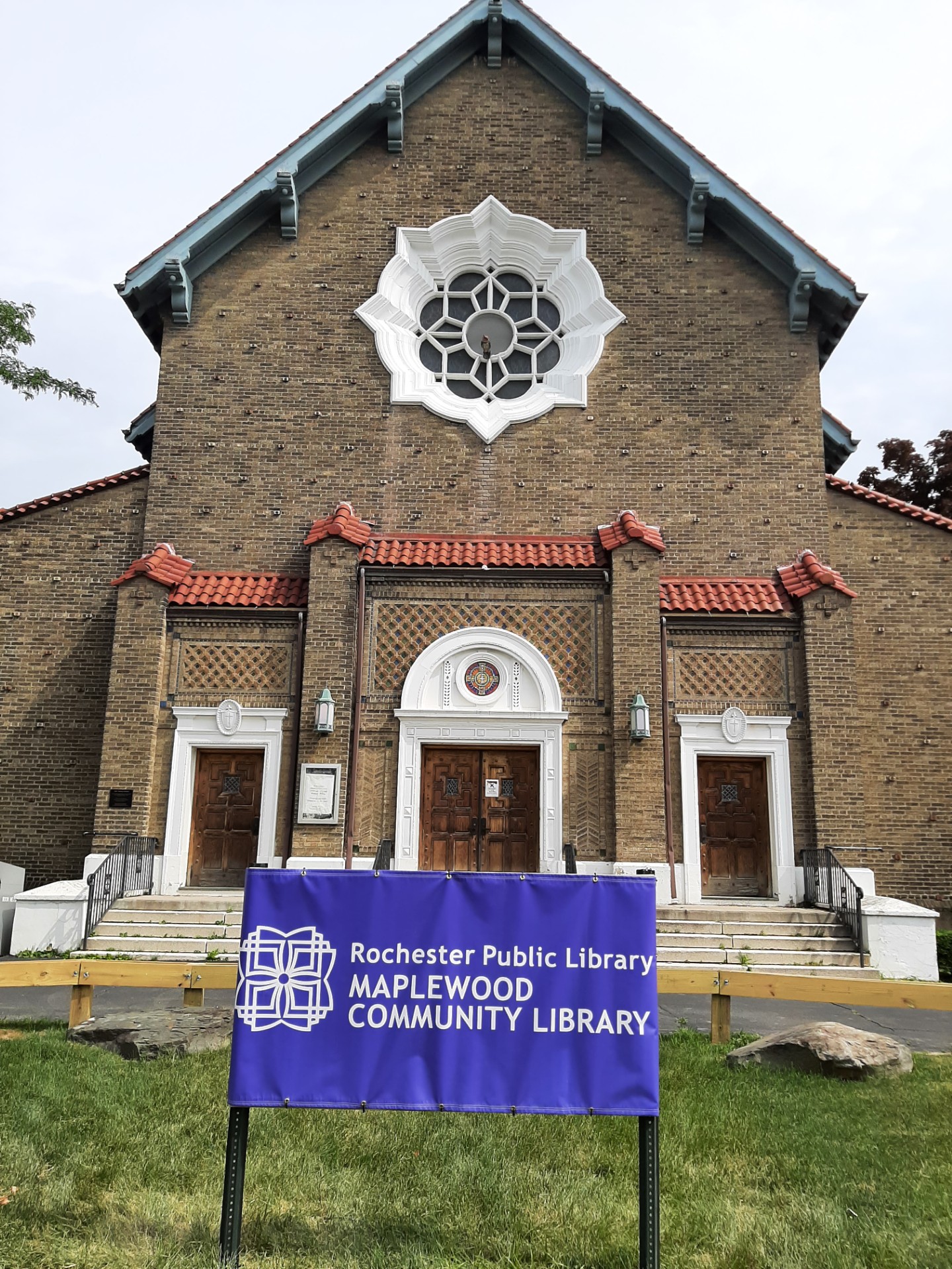 An old church with a large purple yard sign