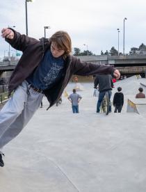 Photo of a young man skateboarding at the Downtown Rochester skatepark.