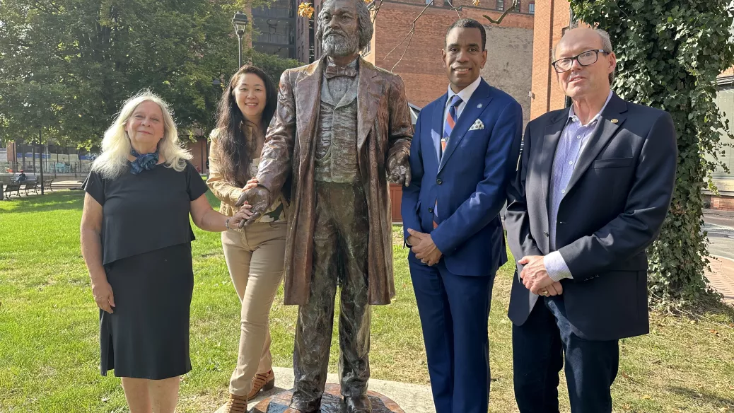 Mayor Evans, Peter Landers, Olivia Kim and Chris Christopher stand with the Frederick Douglass statue in Aqueduct Park