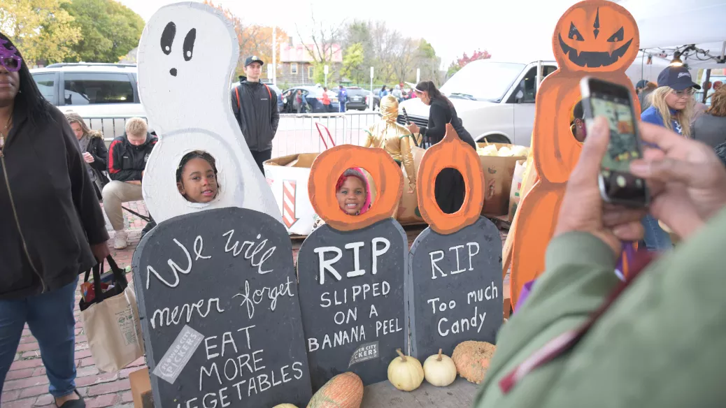 Children posing in a photo opp with gravestones, ghosts and pumpkins at the Public Market