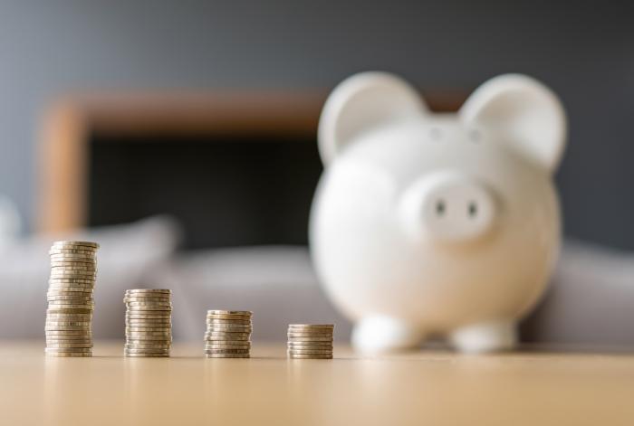 Gett Images photo of loose change currency next to a piggy bank.