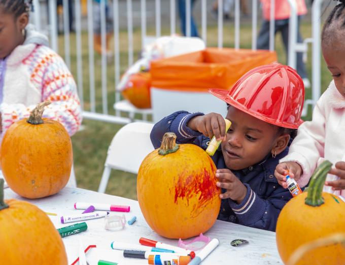 Photo of a child carving a pumpkin at Fall Fest 2023.