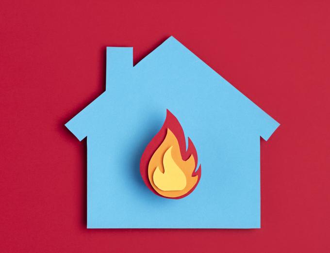 Graphic of a home with a flame to represent fire safety.