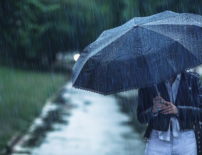 Photo of a person carrying an umbrella in the rain.