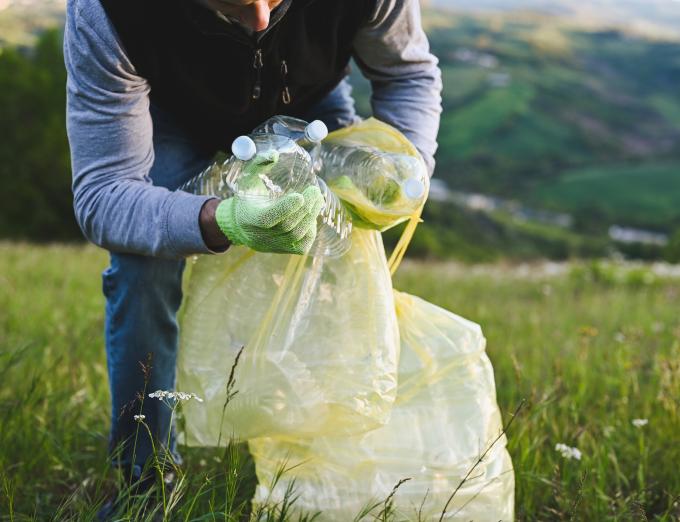 Photo of a person putting recyclable materials in a bag.