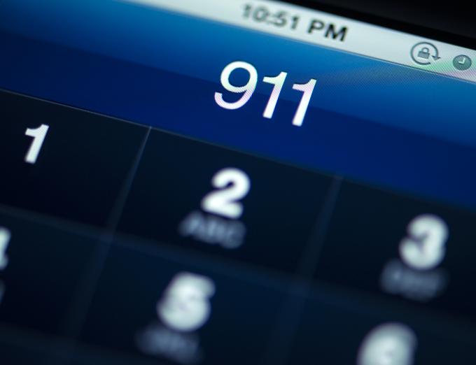 Photo of a phone showing a 911 phone call on its screen.