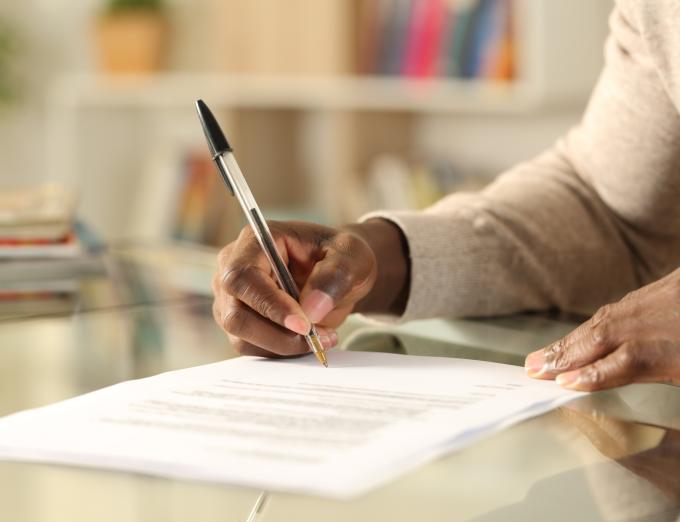 A photo of a person filling out a paper application.