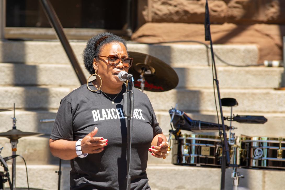 Photo of a woman singing at Rochester City Hall's 2024 Juneteenth Block Party.