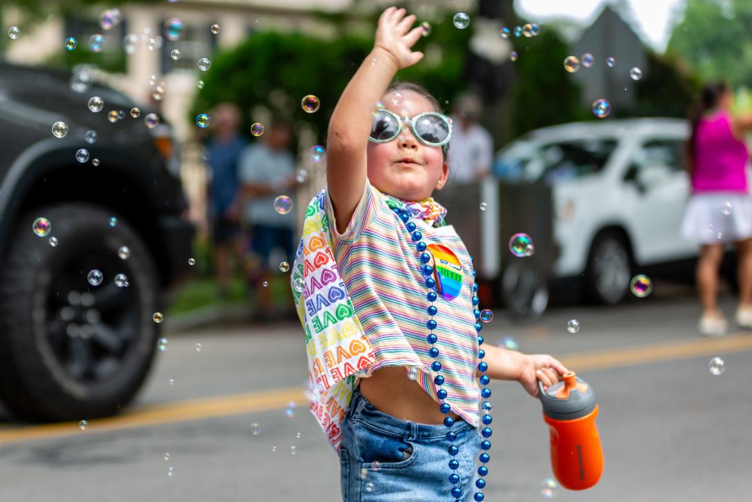 Photo of a girl playing with bubbles at the Rochester Pride Parade.
