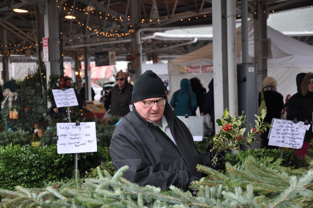 A person shops for greenery and wreaths at the Public Market